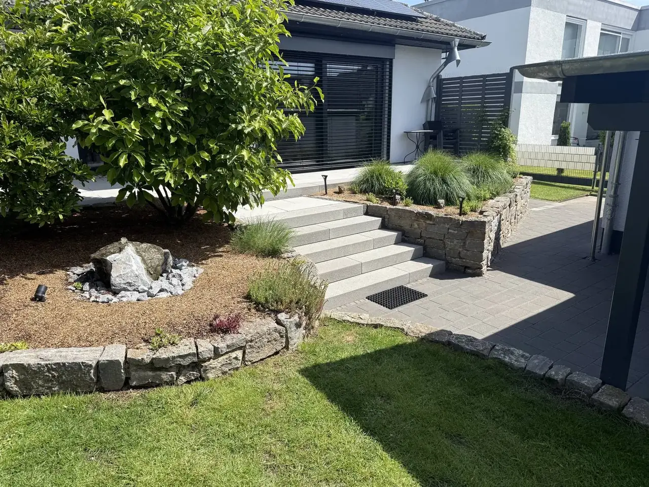 Gartenanlage mit Natursteinmauer und Treppe