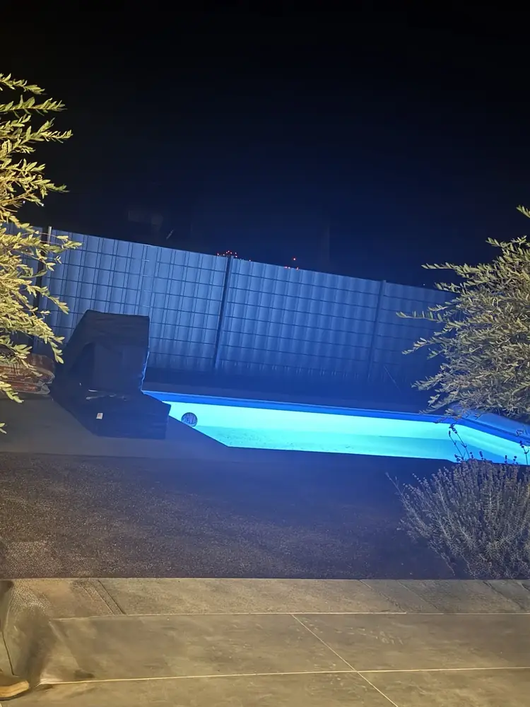 Beleuchtete Poolanlage mit Feinsteinzeugumrandung bei Nacht in Calden